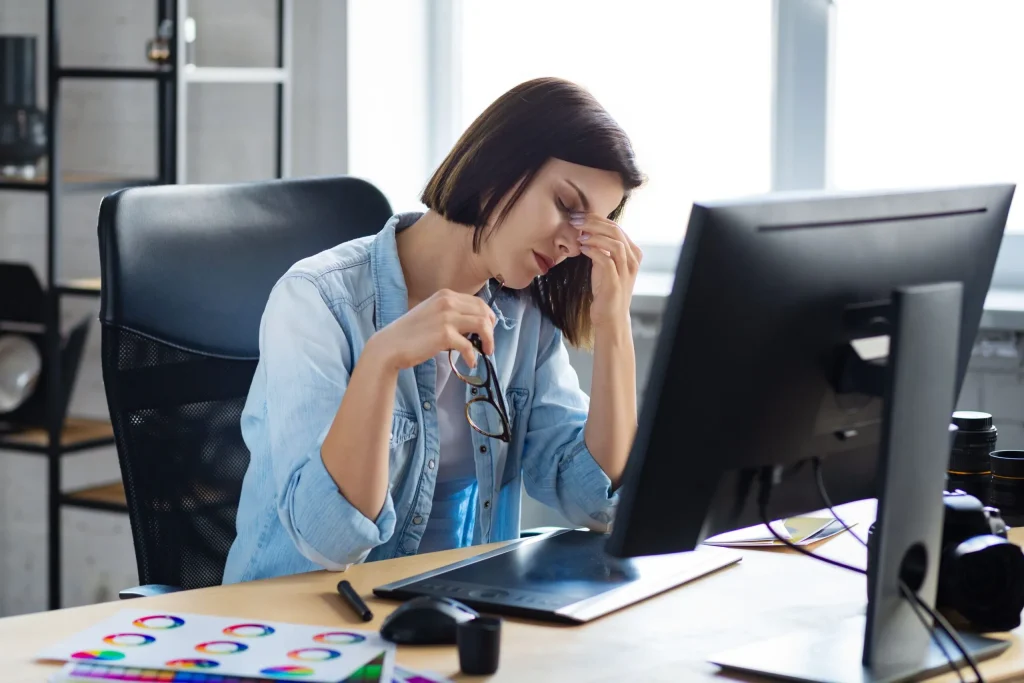A tired woman sitting at her desk working long overtime hours. If you feel are working long hours and are not receiving the legal pay you deserve it is crucial you contact an Austin labor law attorney for wage and hour concerns.