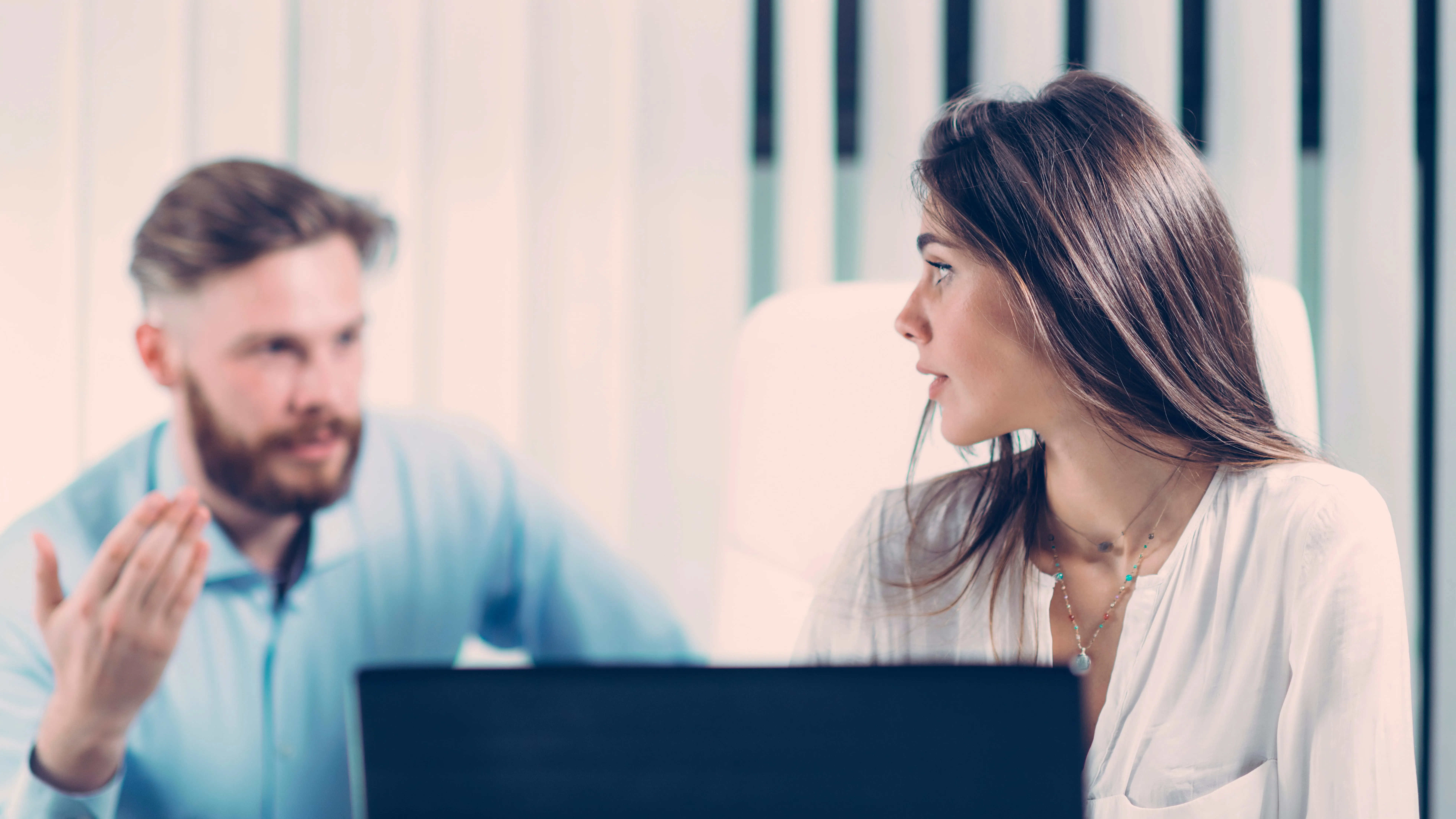 A man sitting close to a female coworker and making her feel uncomfortable. A sexual harassment attorney in San Antonio can help you navigate this scary and confusing process.