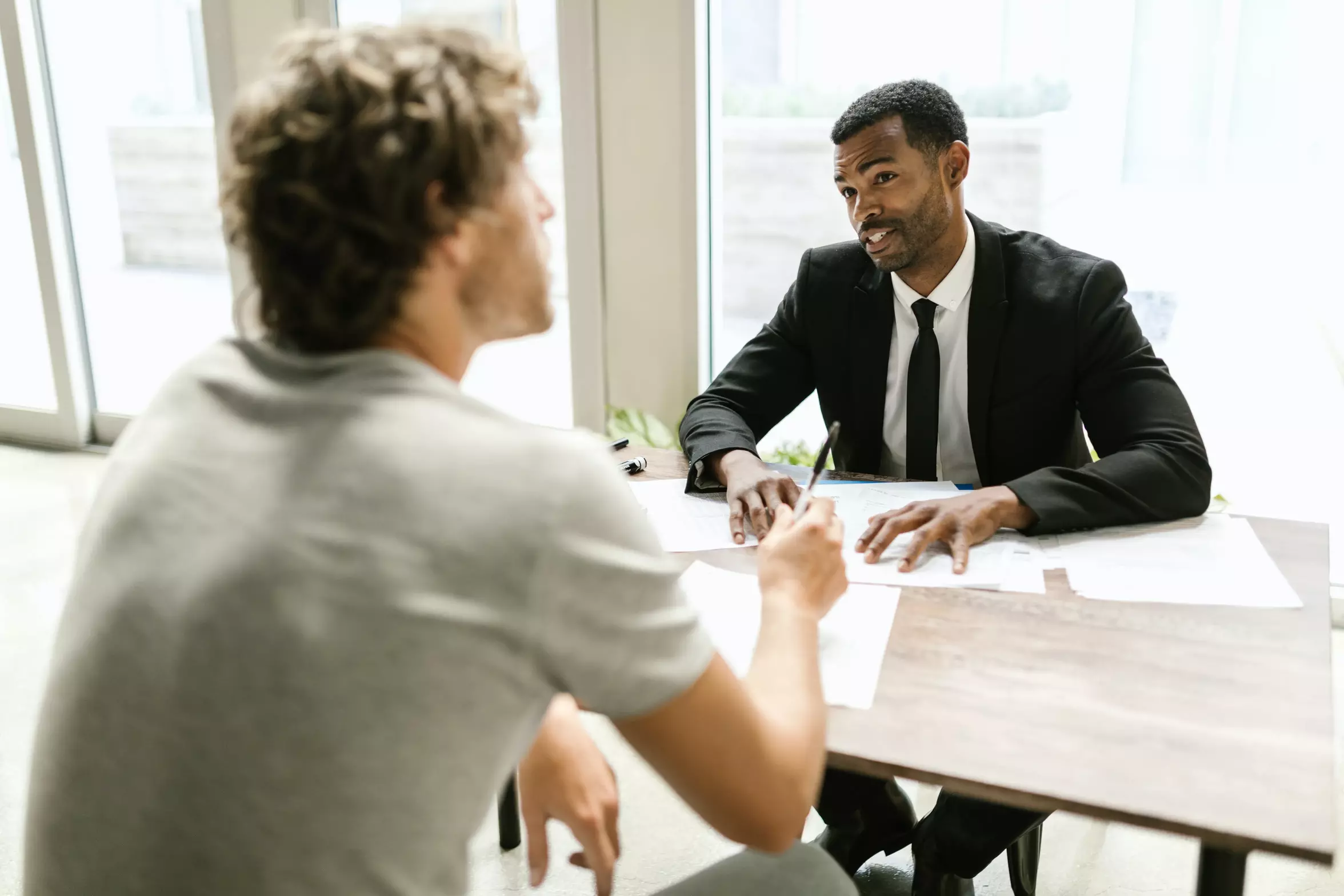 An attorney speaking with their client at a desk.