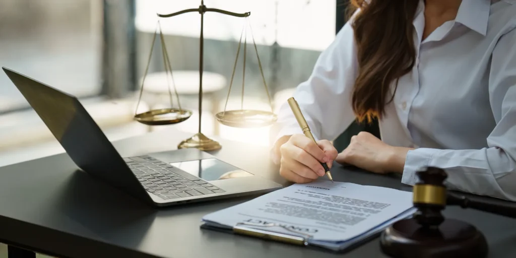 An attorney working at her desk signing a contract.