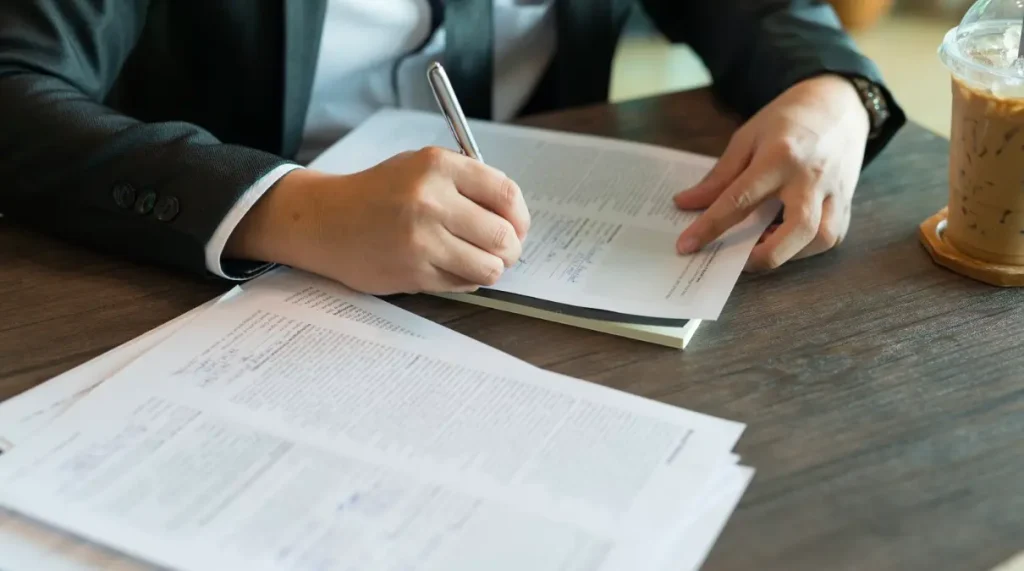 Someone filling out paperwork in a law office.