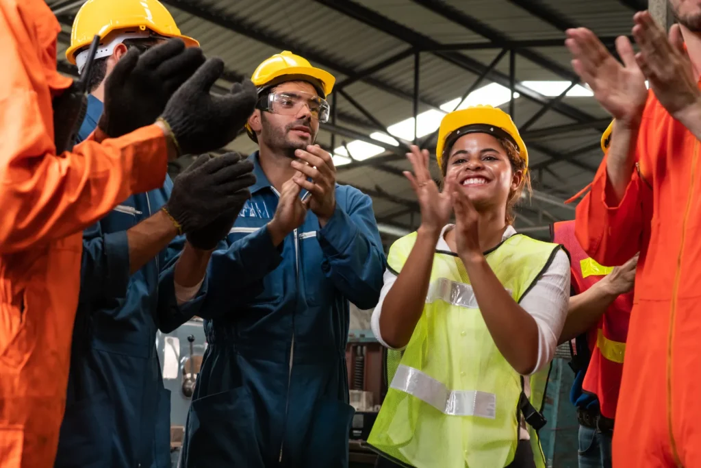 Union workers in hard hats clapping. 