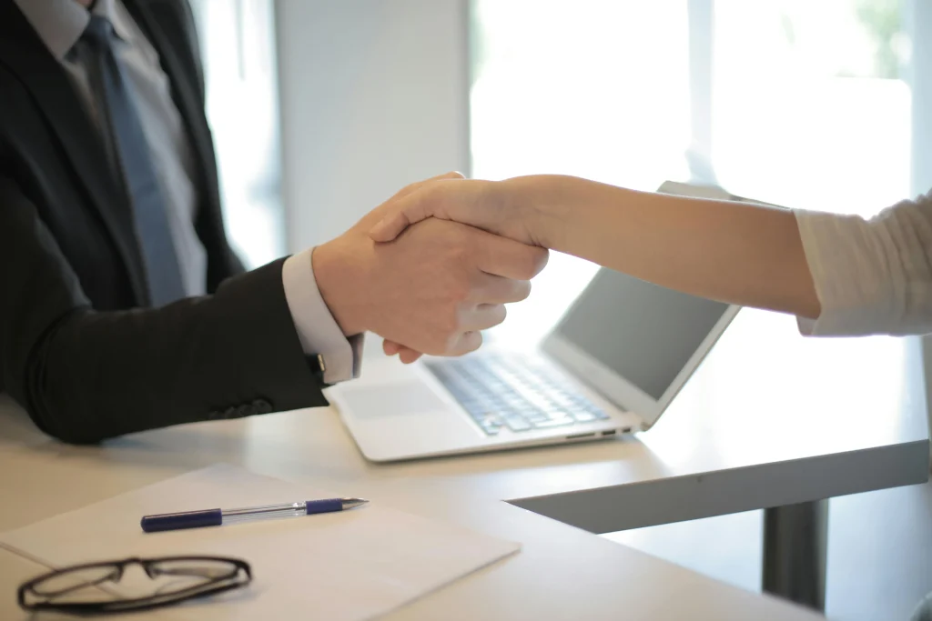 A woman shaking a man's hand.