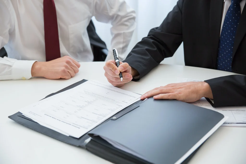 Two men signing a contract.