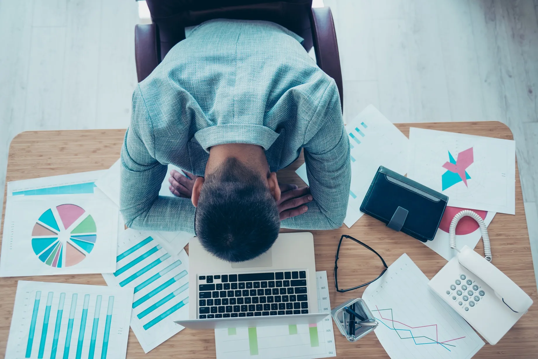 Tired employee with his head on his desk.