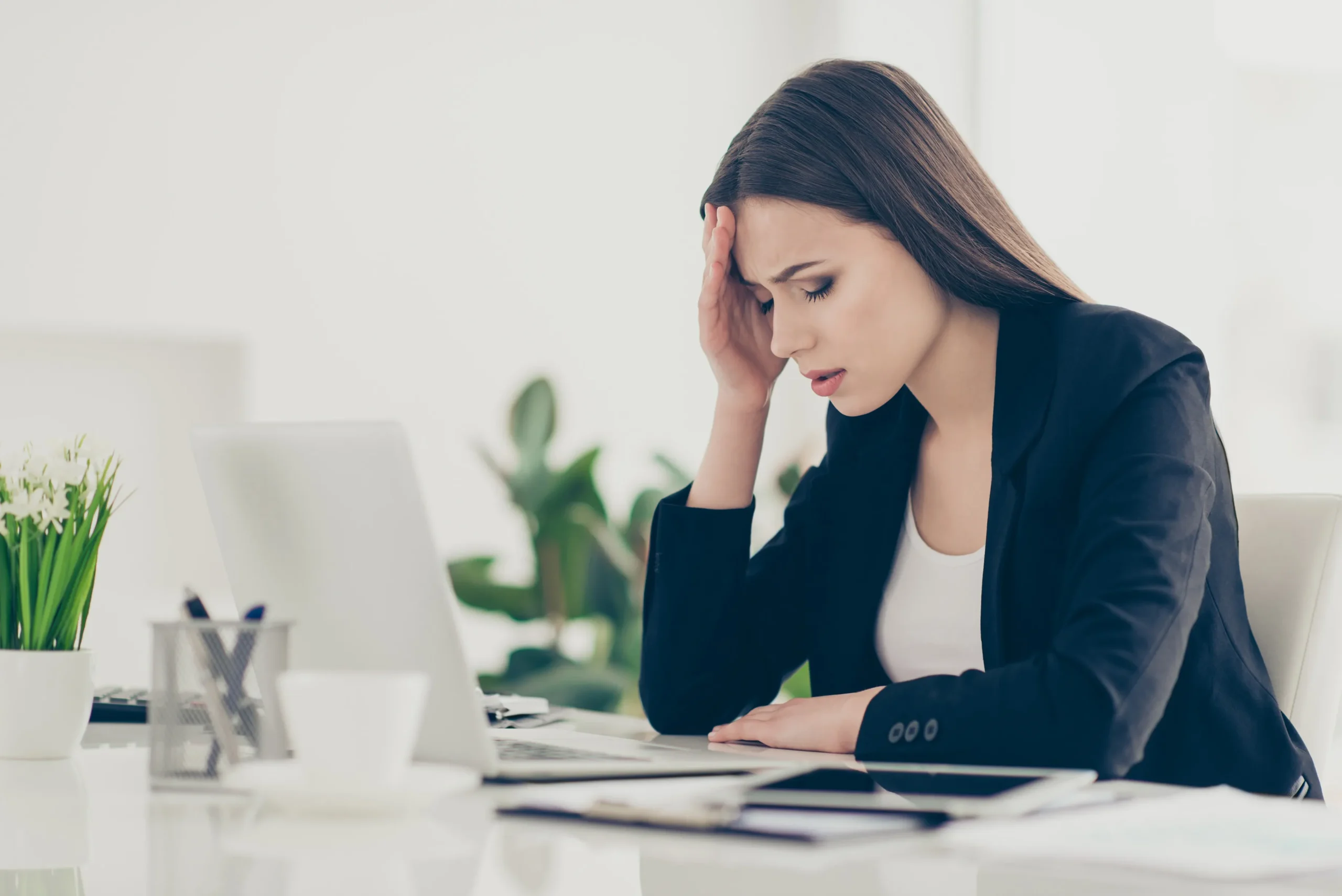 A woman distressed looking at her computer.