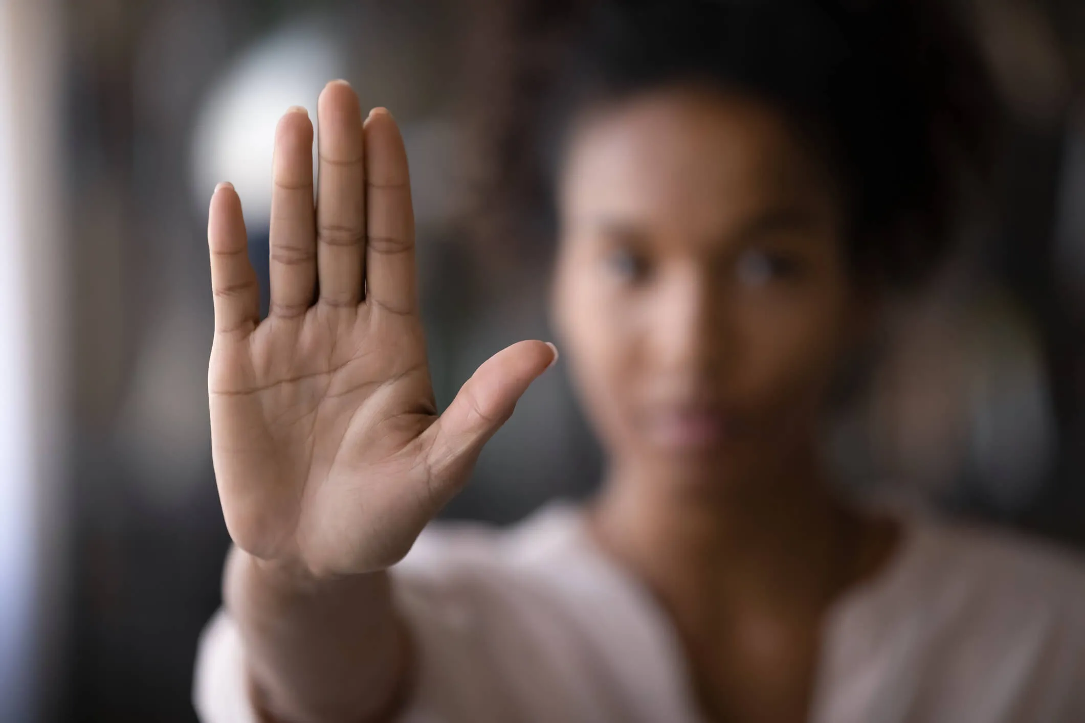A black female with her hand raised, to signify asking to stop.