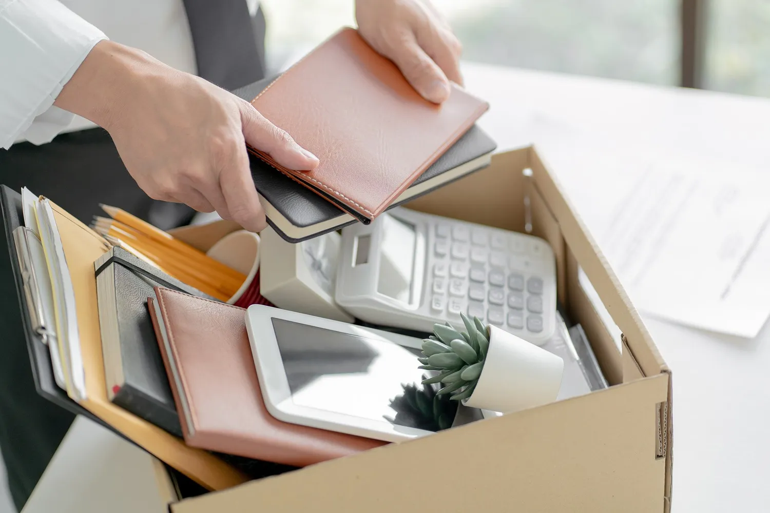 An employee packing a box with their belongings.