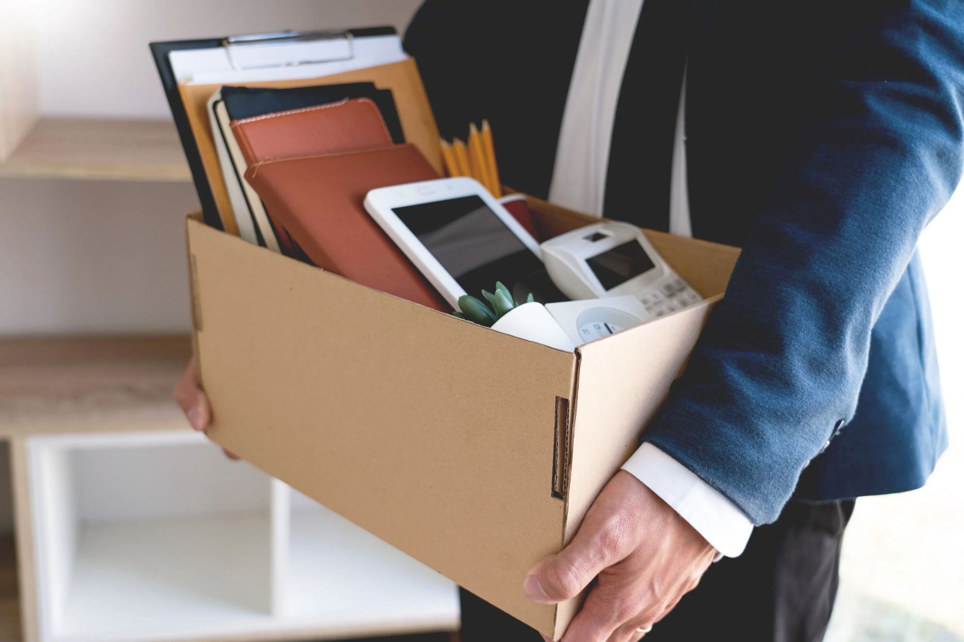 An employee holding a box of their belongings.